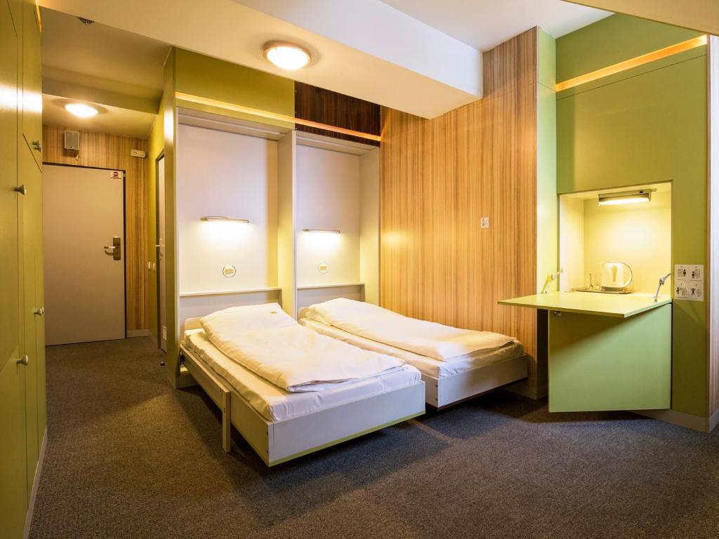 ウストロンにあるElemels Planetのベッド2台とデスクが備わるホテルルームです。
