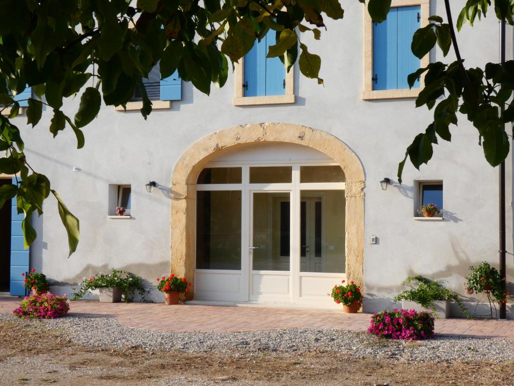 een ingang naar een gebouw met een deur en bloemen bij Agriturismo il Fontanile in Valeggio sul Mincio
