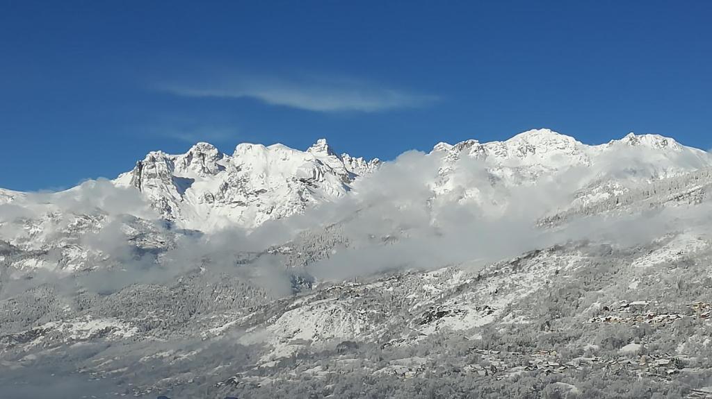 een met sneeuw bedekte berg met wolken ervoor bij Briançon-Serre Chevalier - Apt 3 pièces - 4 à 6 couchages - Au calme-Jardin mis à dispo in Briançon