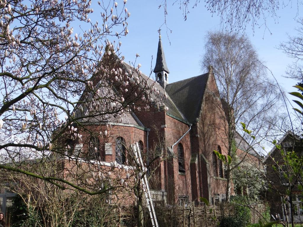 a large brick church with a steeple on top of it at SintAnna B&B PetitHotel in Yerseke