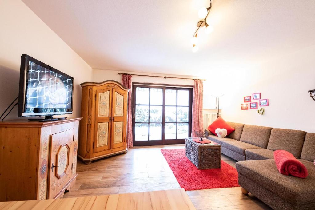 a living room with a couch and a tv at Loewenzahn in Grainau