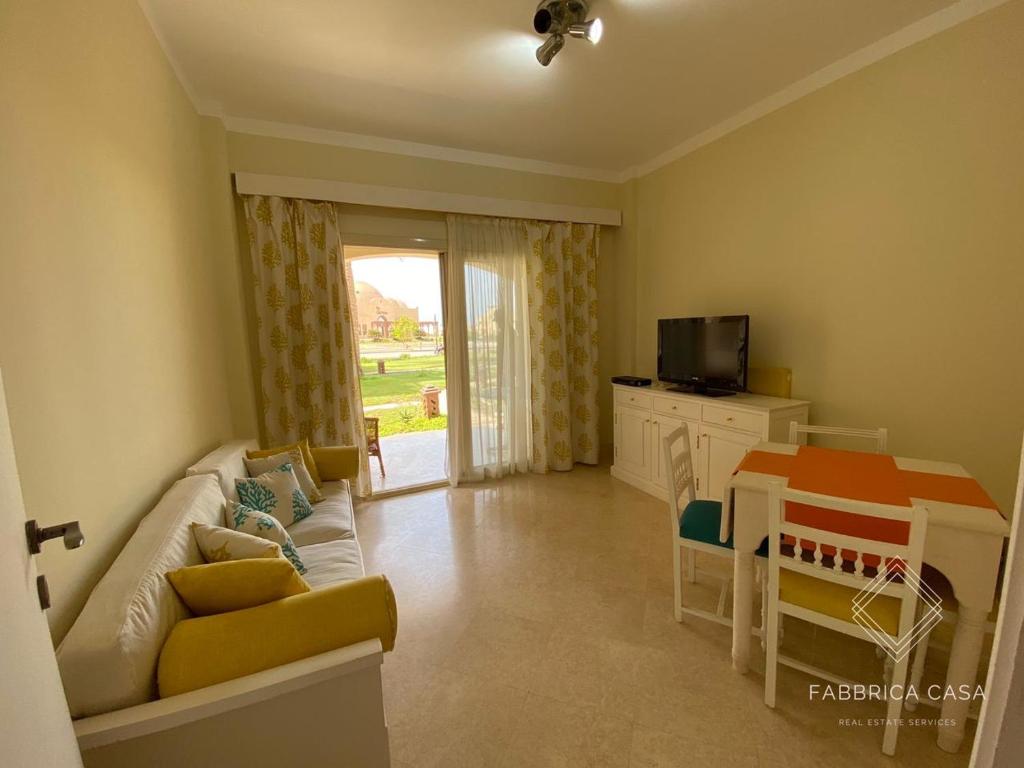 een woonkamer met een bank en een tafel bij One bedroom Comfy Apartment by the sea, in Oriental Coast in Marsa Alam