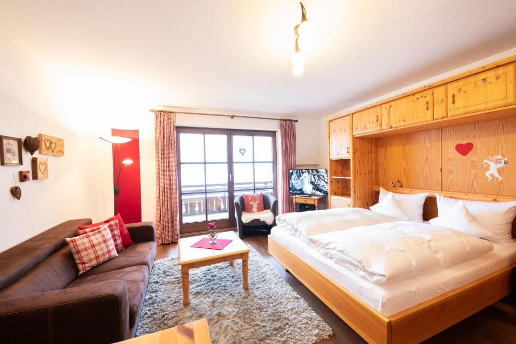 pokój hotelowy z łóżkiem i kanapą w obiekcie Enzian w mieście Grainau