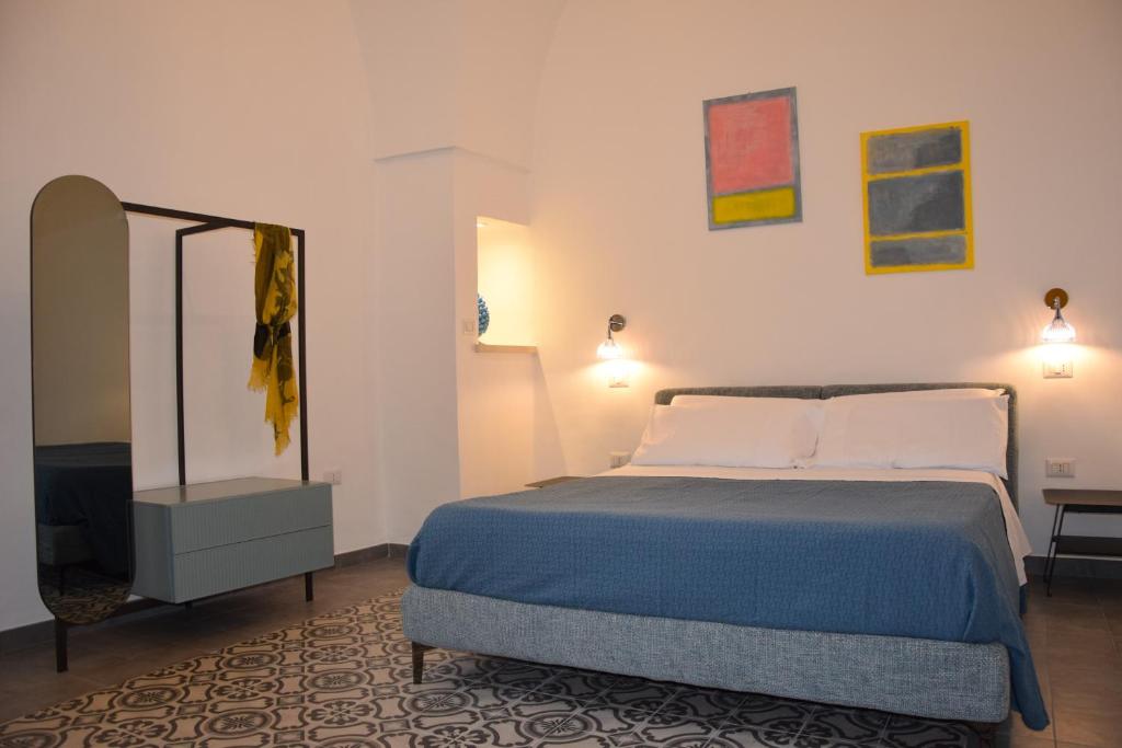a bedroom with a bed and a mirror in it at Palazzo Rimesa in Cutrofiano