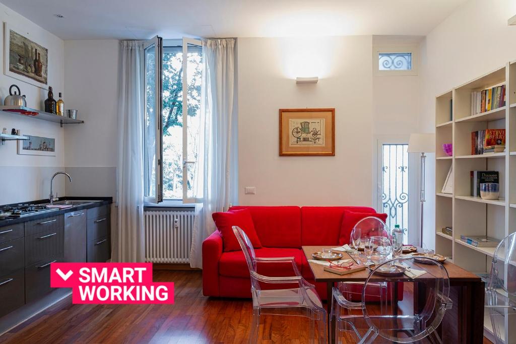 a living room with a red couch and a table at Cozy Family Apartment in Castelletto in Genova