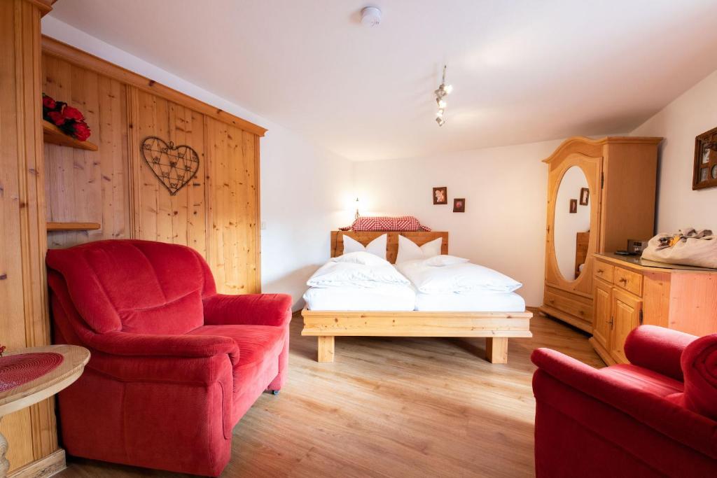 グライナウにあるAlmstüberlのベッドルーム1室(ベッド1台、赤い椅子付)