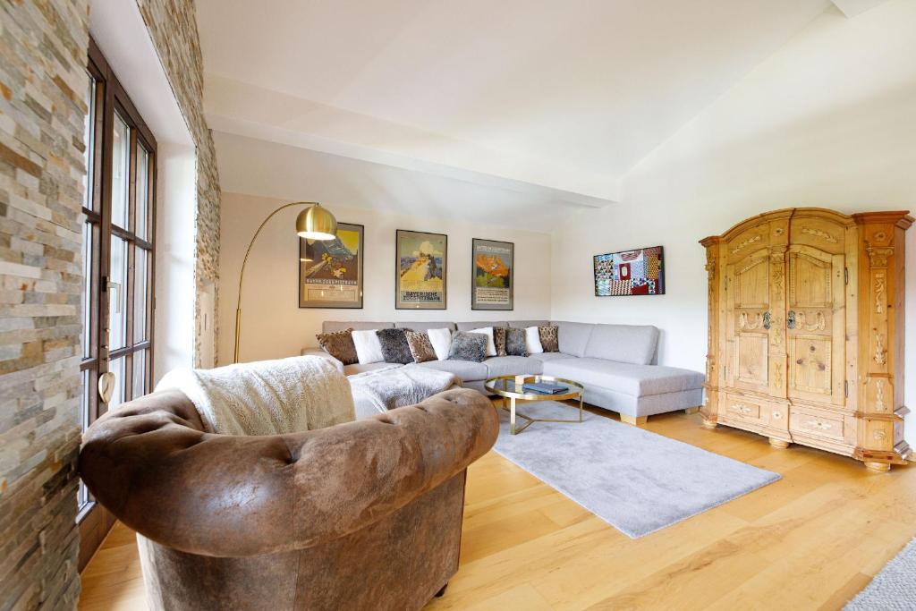 uma sala de estar com um sofá e uma mesa em Dachgeschoss Wohnung Akelei am Fuße der Zugspitze em Grainau