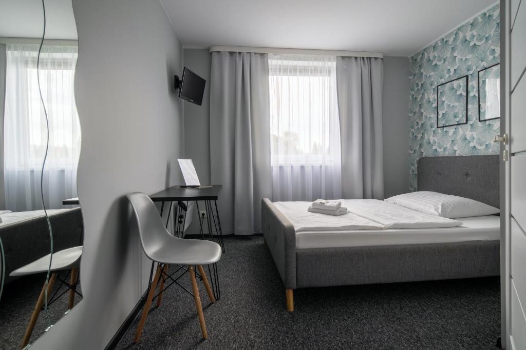 - une chambre avec un lit et une chaise dans l'établissement Noclegi Stop and Sleep, à Zgorzelec