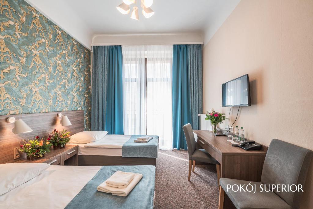 a hotel room with a bed and a desk at Hotel Polonia Centrum in Wrocław