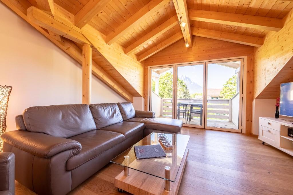 ein Wohnzimmer mit einem Ledersofa und einem TV in der Unterkunft Bergluft in Garmisch-Partenkirchen