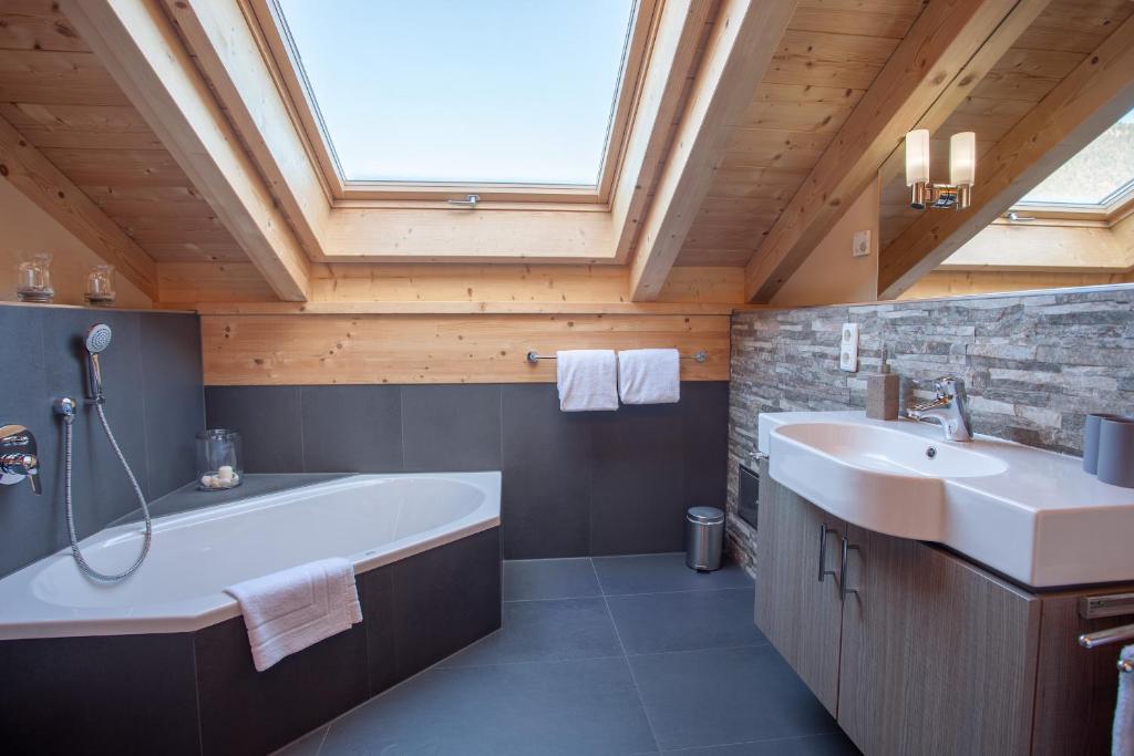 een badkamer met een groot bad en een wastafel bij Rundblick in Farchant
