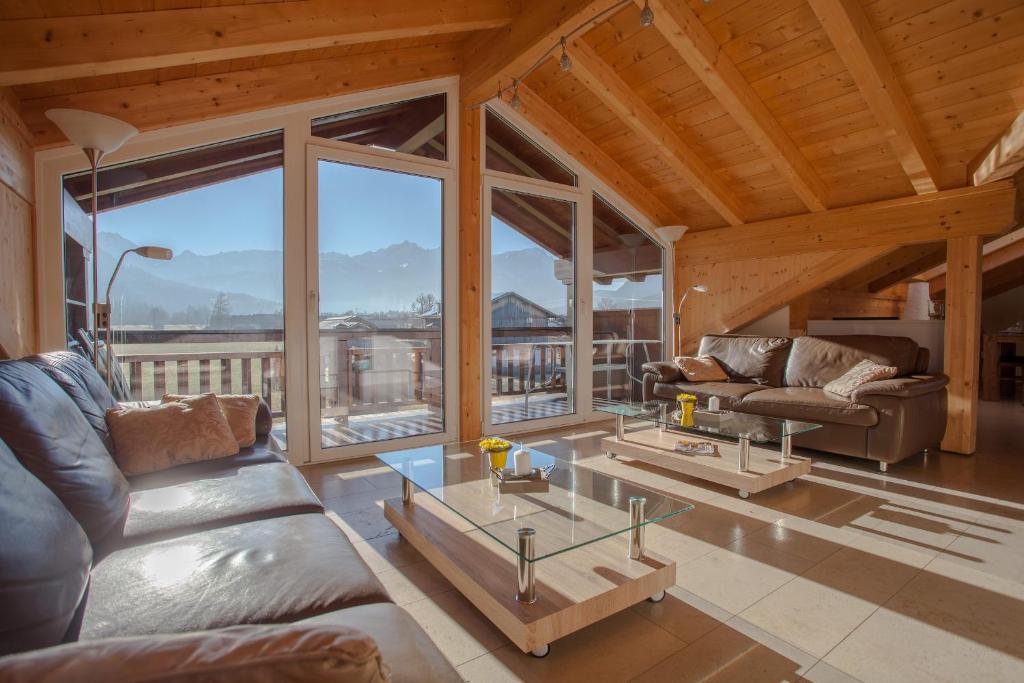 a living room with two couches and a glass table at Rundblick in Farchant