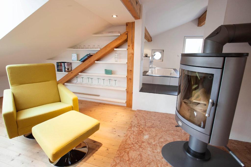 ein Wohnzimmer mit einem TV und einem gelben Stuhl in der Unterkunft Auszeit Maisonette in Garmisch-Partenkirchen