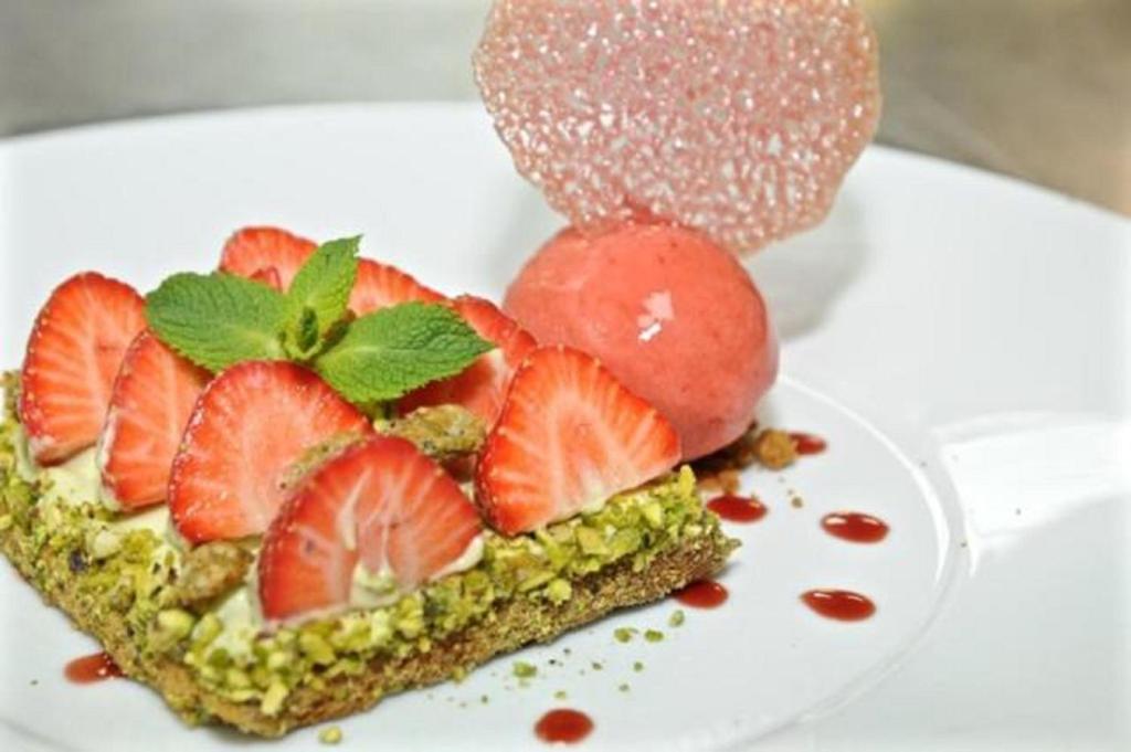 a fruit tart with strawberries on a white plate at Hotel Palladia in Toulouse