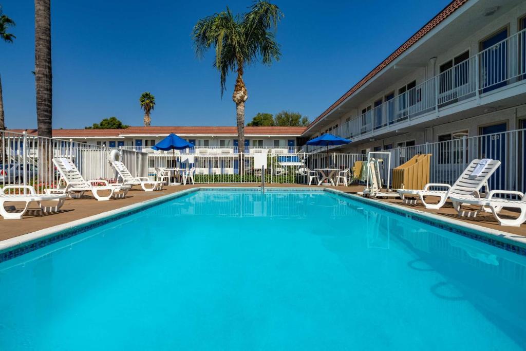 
a beach with a pool, chairs, and a pool table at Motel 6-Sepulveda, CA - Los Angeles - Van Nuys - North Hills in North Hills
