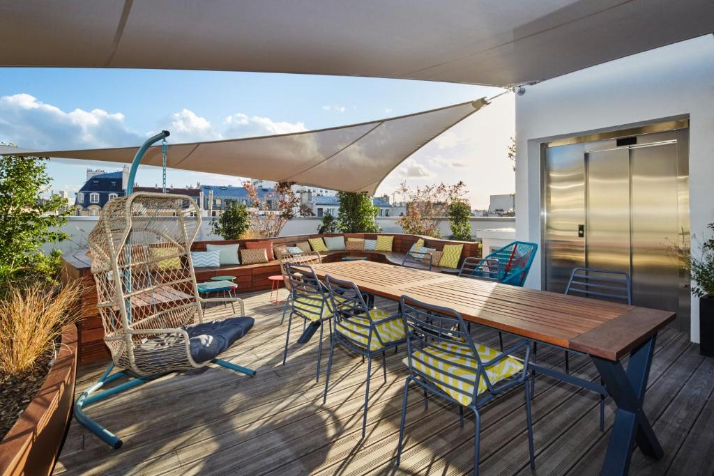 une terrasse avec une table et des chaises en bois dans l'établissement JO&JOE Paris - Nation, à Paris