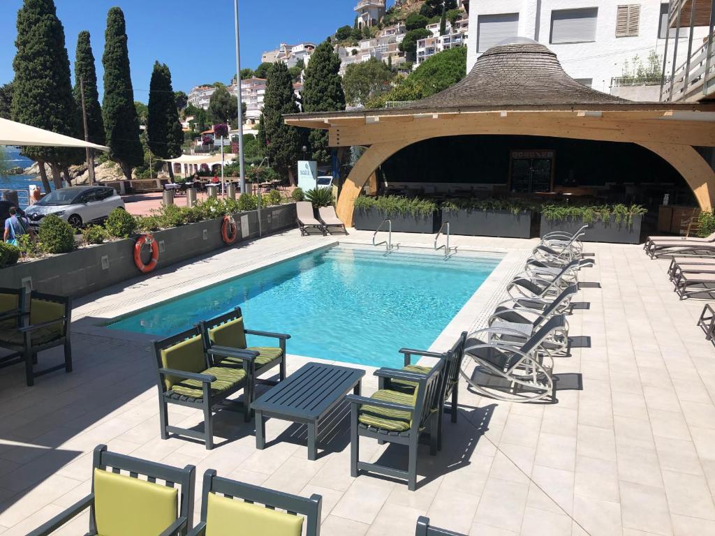 a swimming pool with lounge chairs and a gazebo at Canyelles Platja in Roses