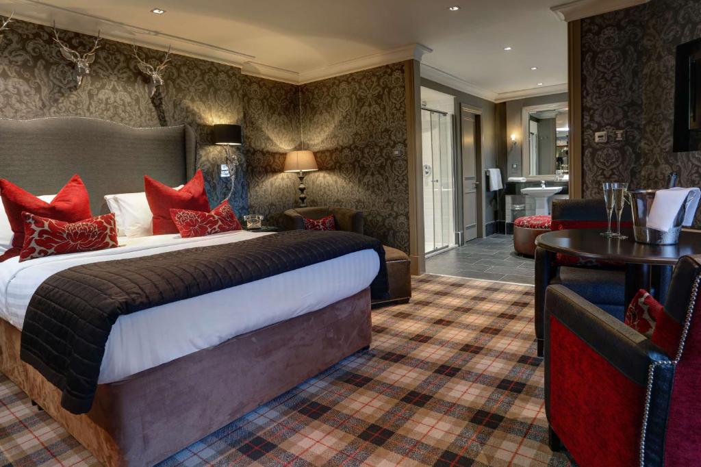 Best Western Eglinton Arms Hotel في إيست كيلبرايد: فندق غرفه بسرير وصاله
