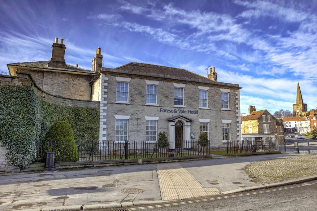 un viejo edificio de ladrillo con una valla delante en Best Western Forest and Vale Hotel, en Pickering