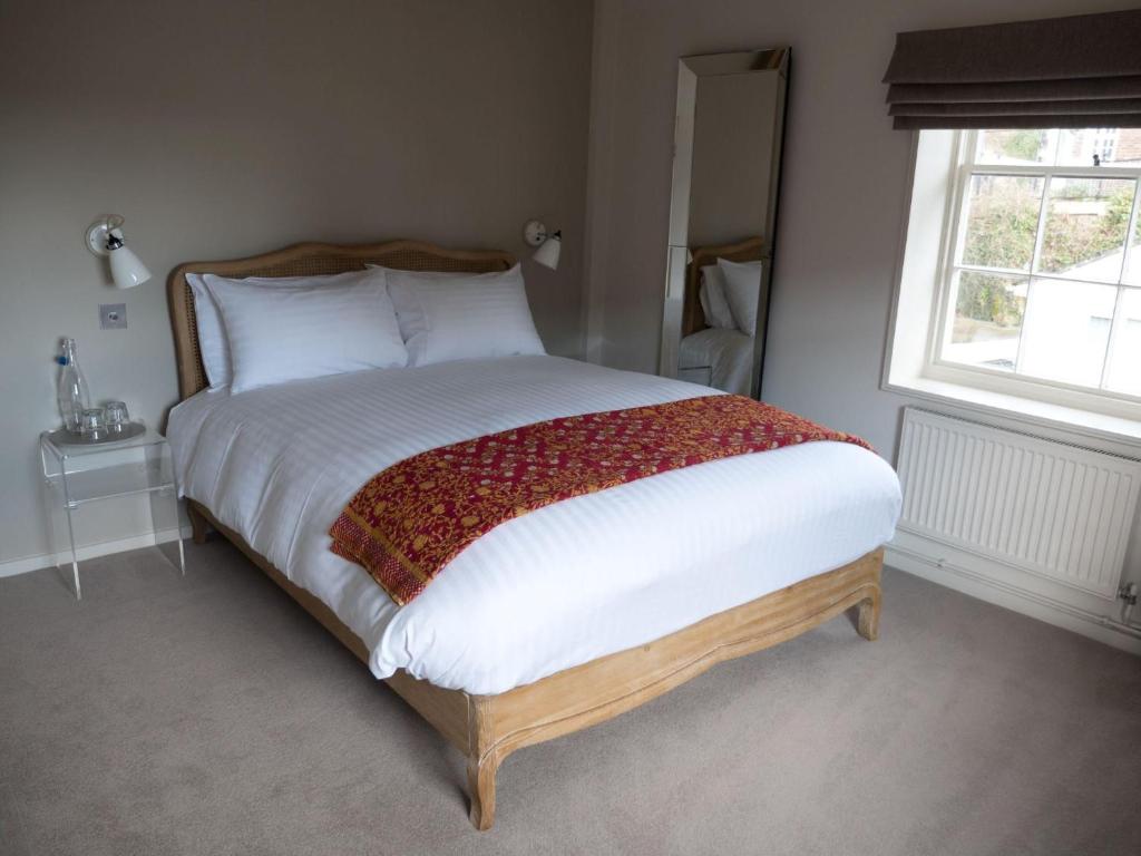 a bedroom with a large bed with white sheets and a window at The Ship Inn in Rye