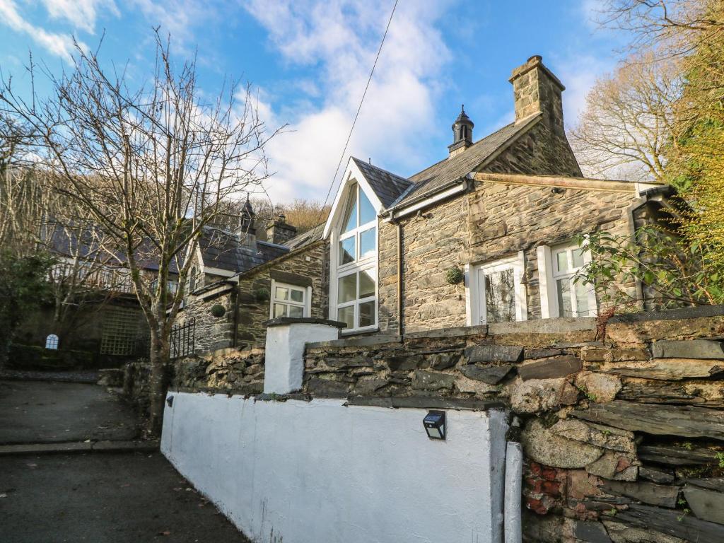 Casa de piedra con pared de piedra en Yr Hen Ysgol, The Old School, en Porthmadog