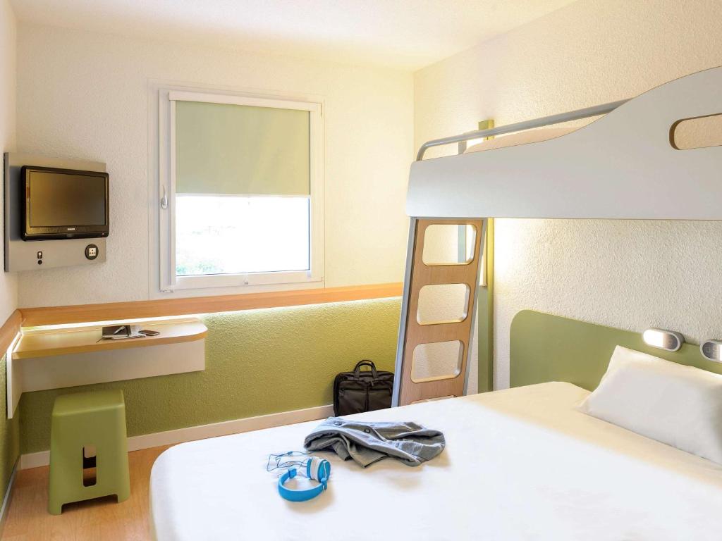 a bedroom with a bed and a bunk bed at ibis budget Basel Pratteln in Pratteln