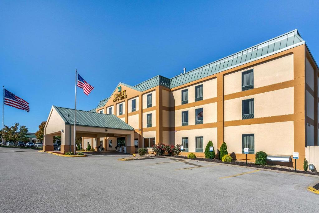 um hotel com duas bandeiras americanas em frente em Quality Inn & Suites - Jefferson City em Jefferson City