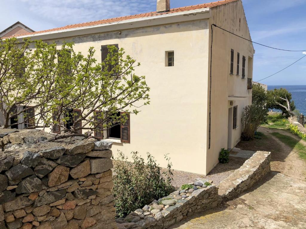 Casa blanca con pared de piedra en A Casa di Babbo en Algajola