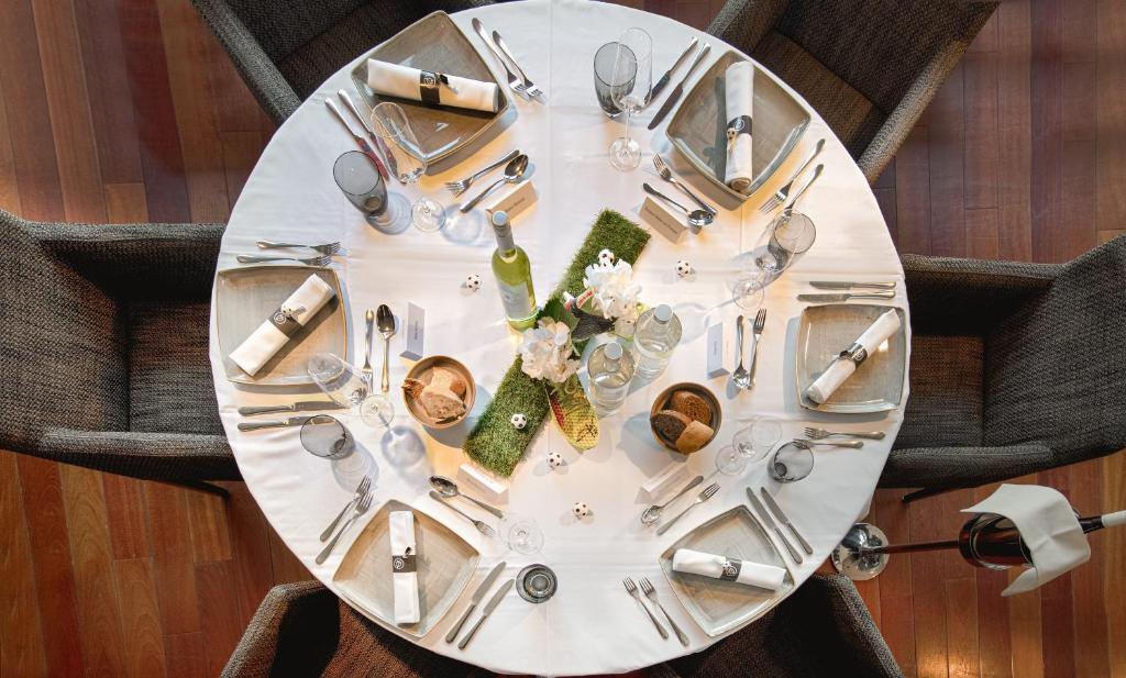 een tafel met een witte plaat en zilveren bestek bij Tulip Inn Hotel Düsseldorf Arena in Düsseldorf