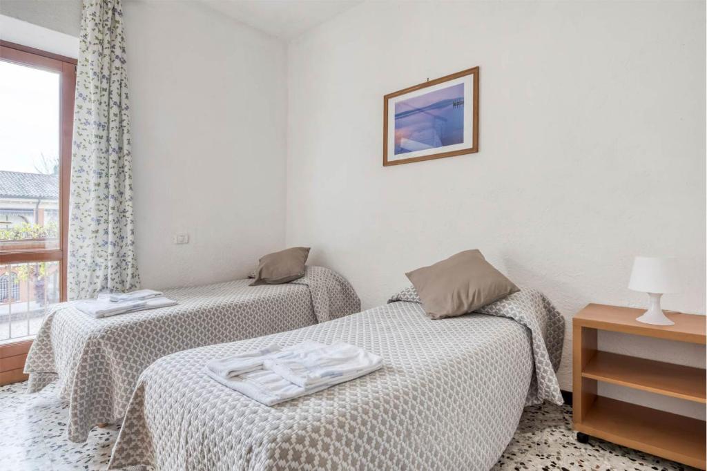 two twin beds in a room with a window at Agriturismo La Filanda in Manerba del Garda