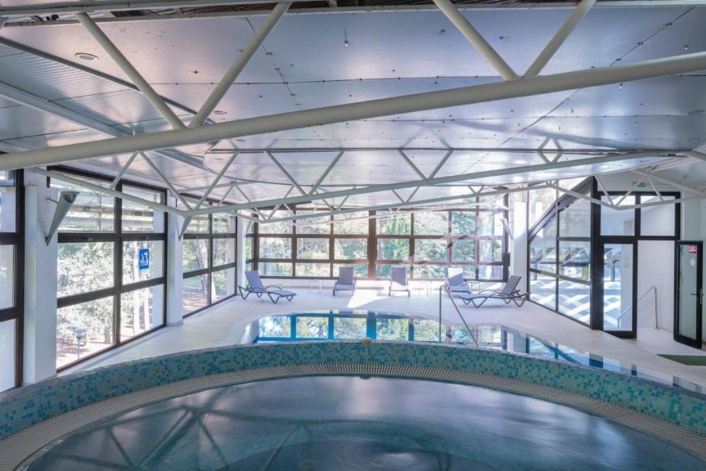 a swimming pool in a building with windows at Hotel Flores in Poreč