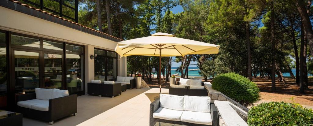 a yellow umbrella sitting in front of a building at Hotel Flores in Poreč
