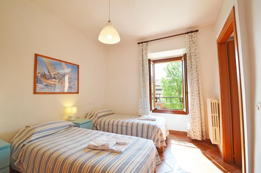 two beds in a room with a window at Agriturismo La Filanda in Manerba del Garda