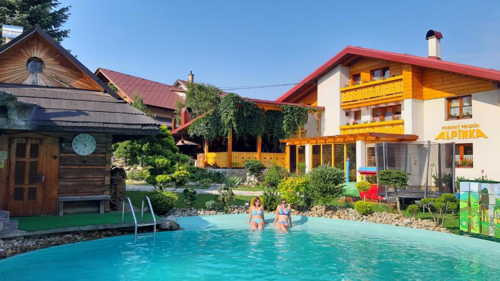 two women in the swimming pool at a resort at Rodinné apartmány Alpinka in Oščadnica