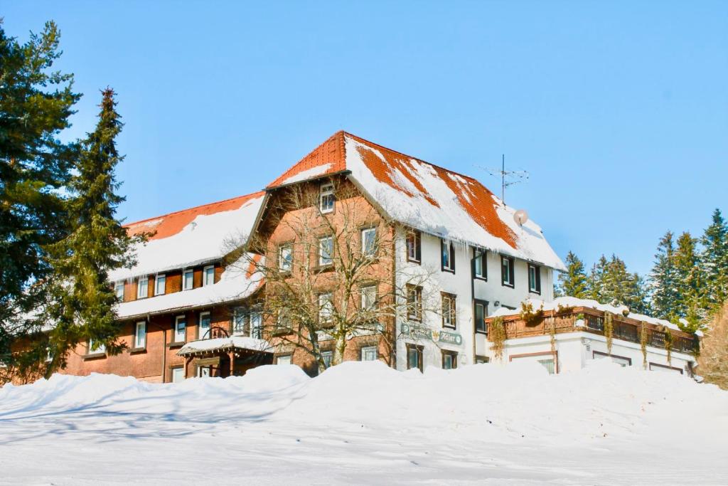 a large building with a snow covered roof at Gasthaus Adler Fohrenbühl in Lauterbach