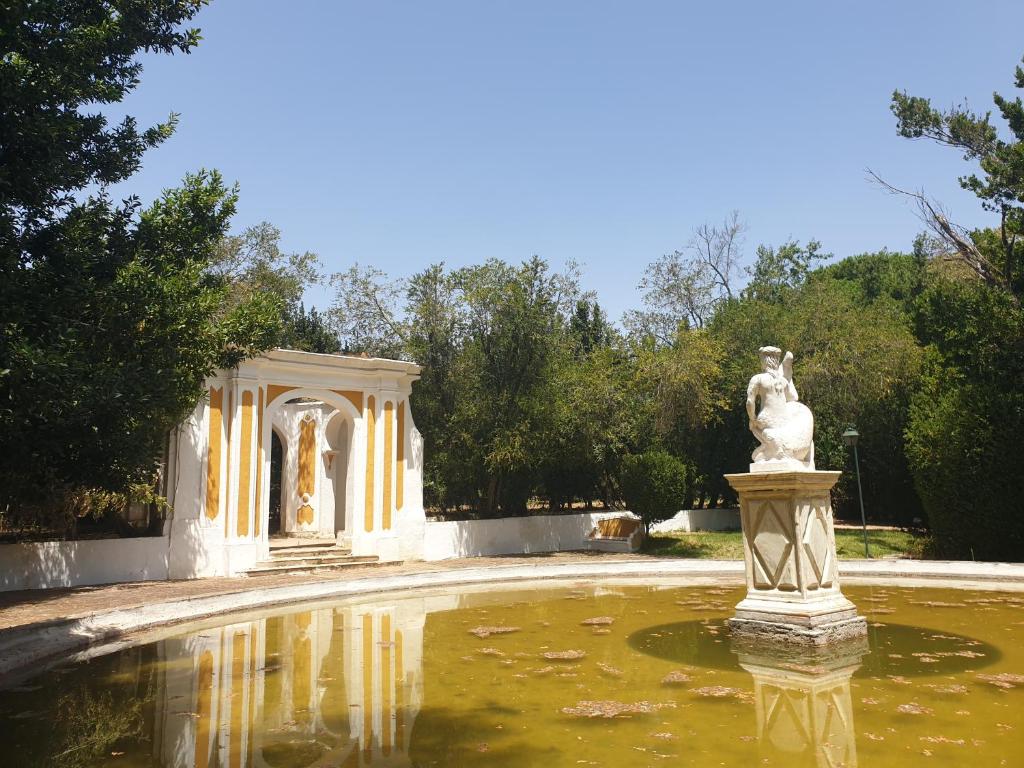 einen Brunnen in einem Garten mit einer Statue im Wasser in der Unterkunft Hotel Rural Quinta de Santo Antonio in Elvas