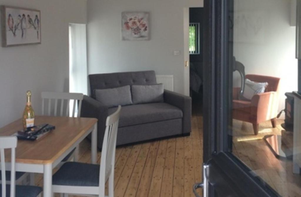 een woonkamer met een bank en een tafel bij Cosy stylish 1-Bed Apartment in South Armagh in Cullyhanna