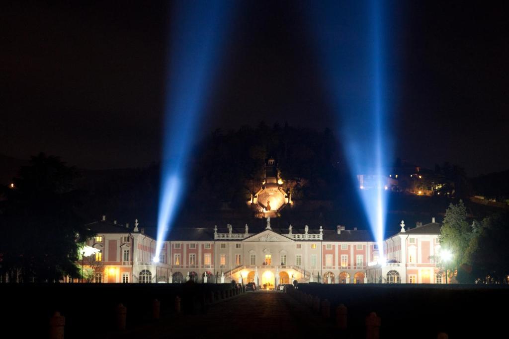 ein großes Gebäude mit blauen Lichtern in der Nacht in der Unterkunft Villa Fenaroli Palace Hotel in Rezzato