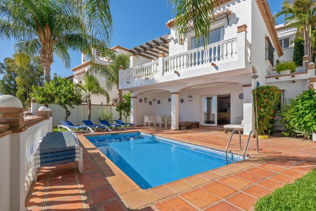 a villa with a swimming pool and a house at 4 bedrooms house at Almunecar 400 m away from the beach with sea view private pool and furnished terrace in Almuñécar