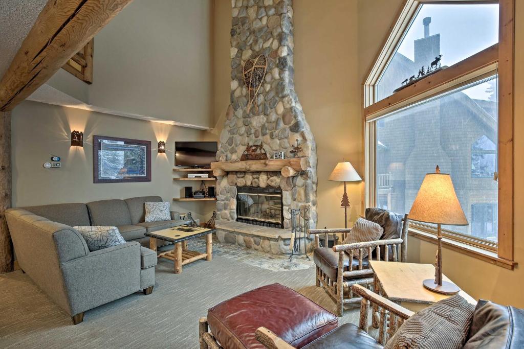 una gran sala de estar con chimenea de piedra. en Comfy Lutsen Mountain Villa with Balcony and Grill, en Lutsen