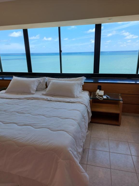 a hotel room with a bed and a window at Euro Suite Recife Boa Viagem in Recife