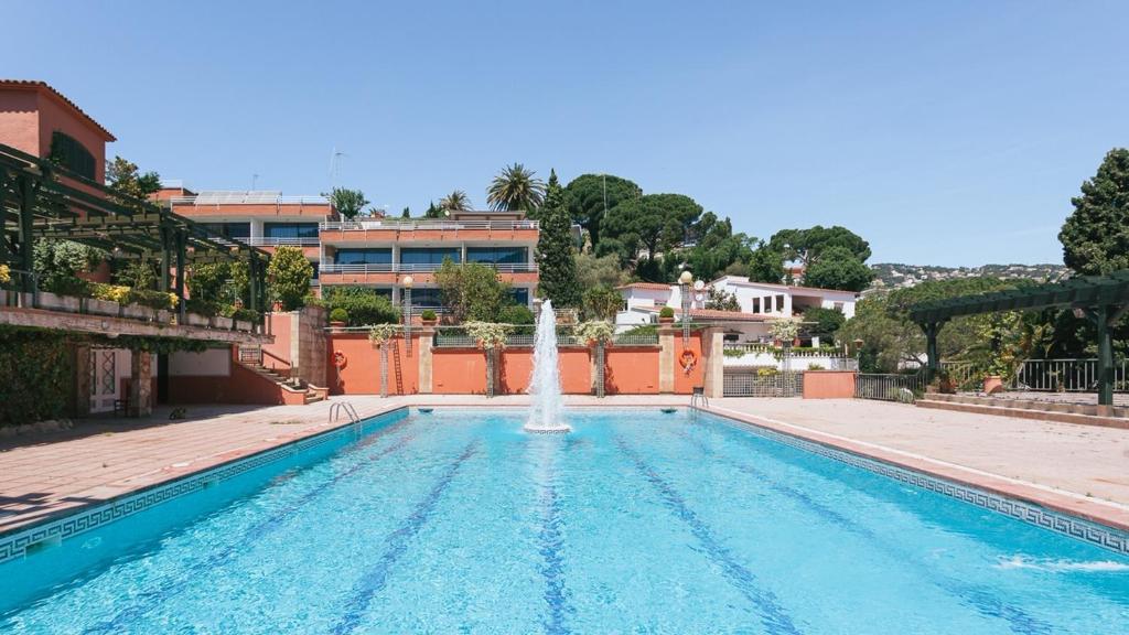 a swimming pool with a fountain in the middle at El Trull Apartaments in Lloret de Mar