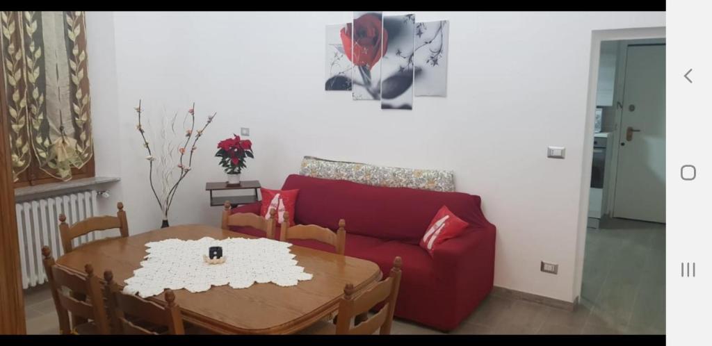 een woonkamer met een rode bank en een tafel bij APPARTAMENTI DEI MILLE in Novi Ligure
