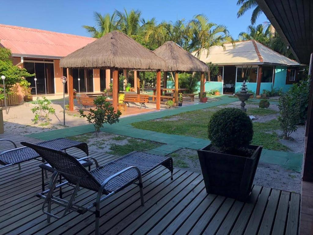 a deck with chairs and tables and a pavilion at Pousada Ilha do Mel in Ilha do Mel