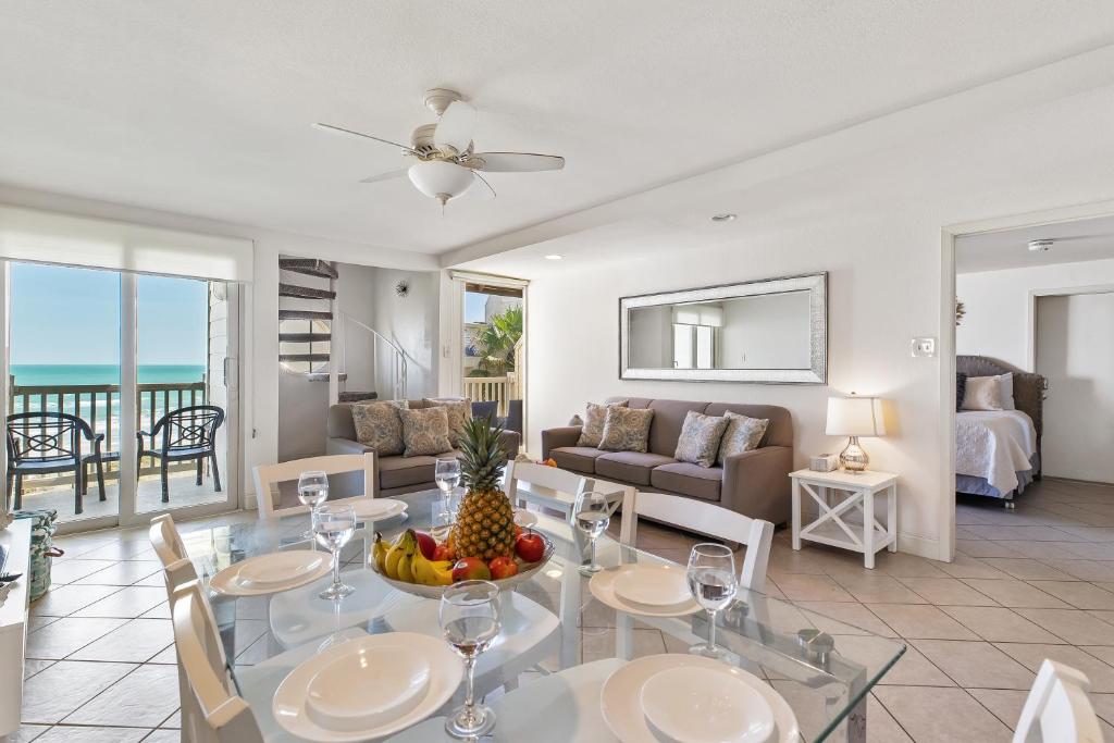 uma sala de estar com uma mesa e cadeiras e um sofá em Recently renovated! 3 beachfront balconies Beautiful and fully equipped condo em South Padre Island