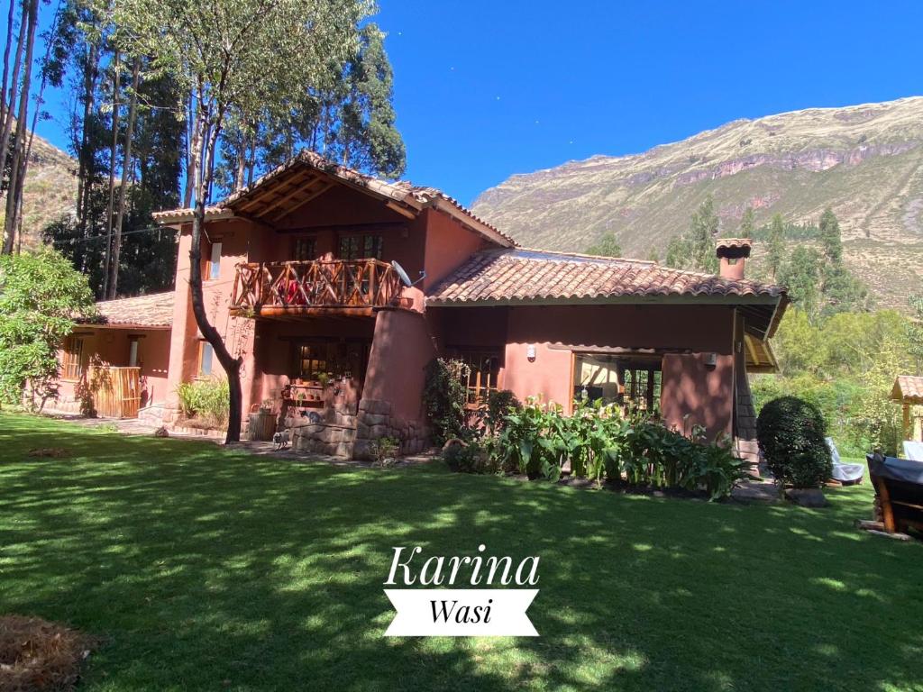 a house with a green lawn in front of it at Karina Wasi in Pisac