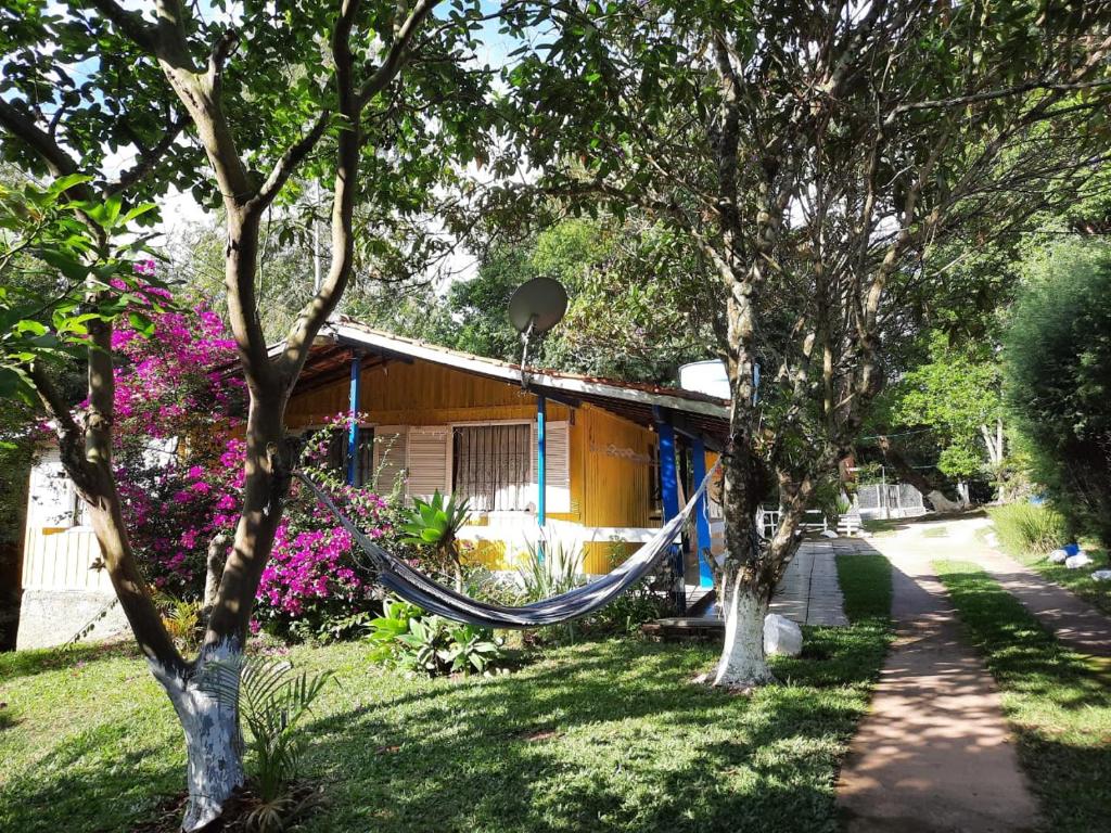 a hammock in front of a house with trees at Hospedagem Chalé pousada Chácara Cantinho do Mozão in São Roque