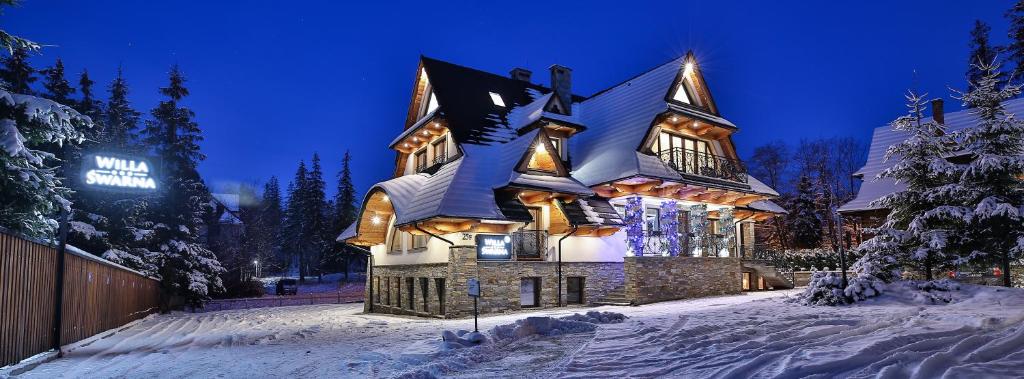 a house covered in snow at night at Willa Śwarna I in Zakopane