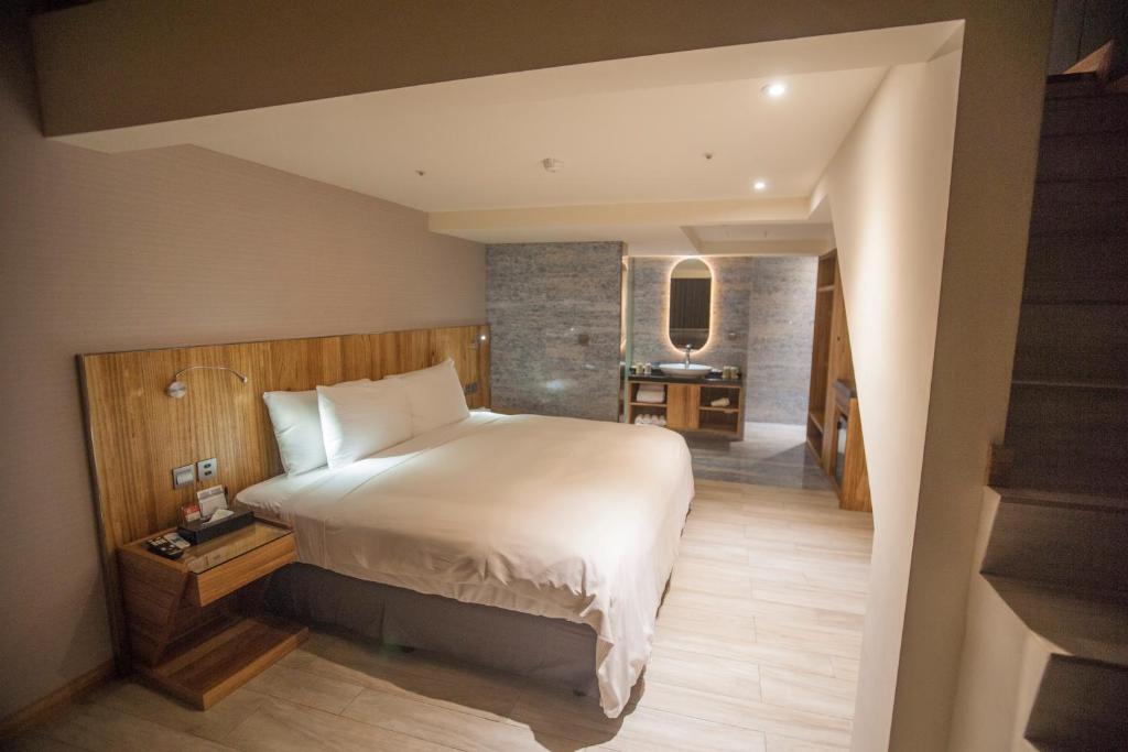 a bedroom with a large bed and a desk at LE LE Motel in Pingtung City