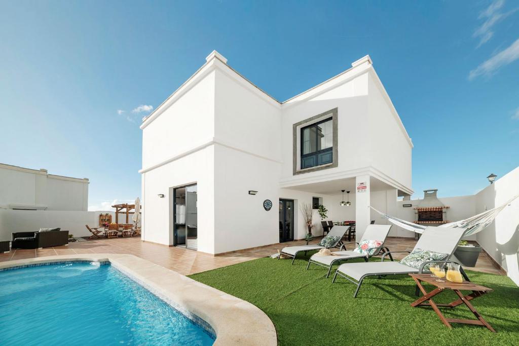 une villa avec une piscine et une maison dans l'établissement Villa Clara, à Playa Blanca